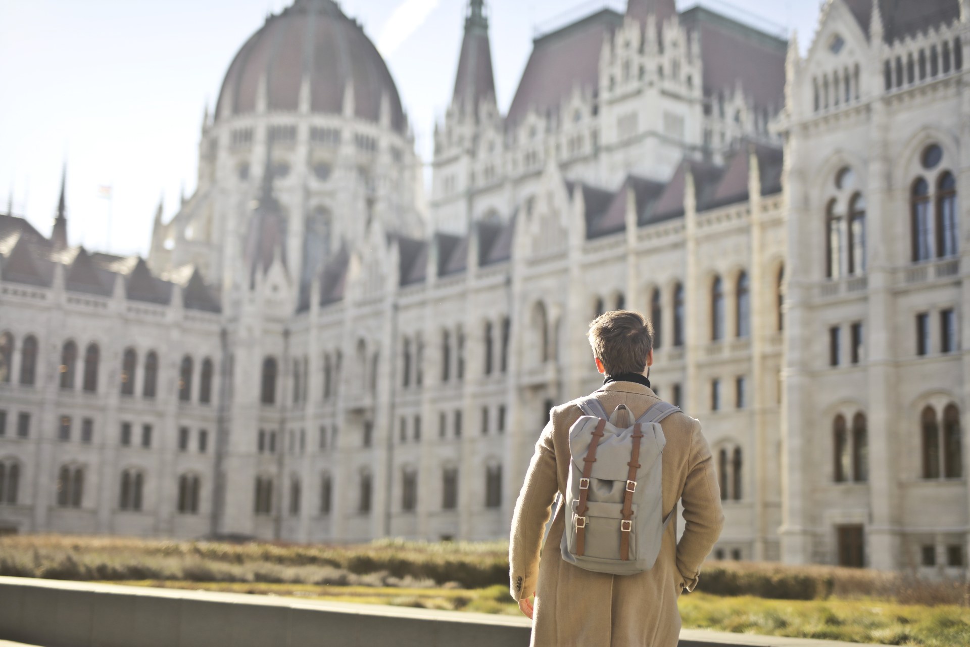 Hátizsákos fiatal férfi a budapesti Országház előtt